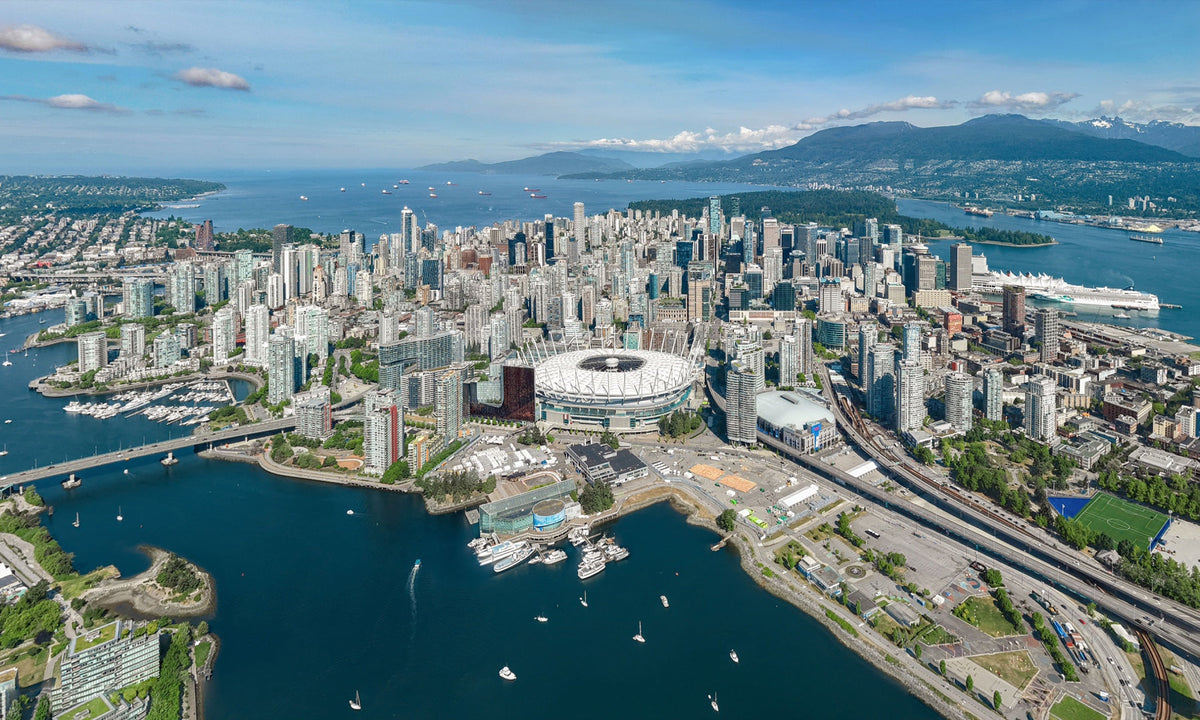 Aerial view of downtown Vancouver with False Creek and the North Shore Mountains in the distance
