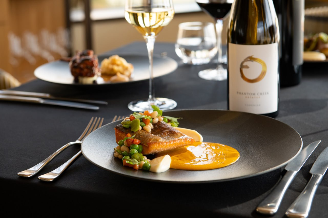 Fine-dining plate with Phantom Creek wine at a refined table setting.